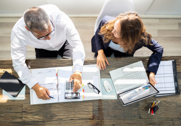 Businesspeople Using Laptop In Office